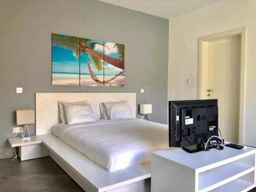 a bedroom with a bed and a desk with a tv at Amber Villas Diani in Diani Beach