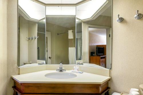 La salle de bains est pourvue d'un lavabo et d'un grand miroir. dans l'établissement Baymont by Wyndham Amarillo East, à Amarillo