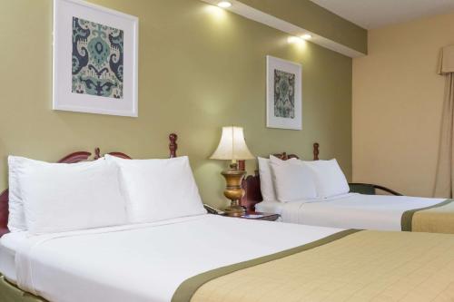 Habitación de hotel con 2 camas y almohadas blancas en Baymont by Wyndham Lakeland, en Lakeland