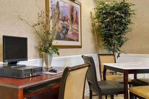 a desk with a computer and a table with chairs at Baymont by Wyndham Eufaula in Eufaula