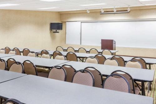 a conference room with tables and chairs and a whiteboard at Baymont by Wyndham Elkhart in Elkhart