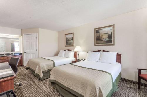 a hotel room with two beds and a kitchen at Baymont by Wyndham Hickory in Hickory