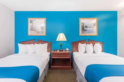 two beds in a hotel room with blue walls at Baymont by Wyndham Duncan/Spartanburg in Duncan