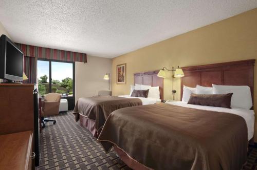 A bed or beds in a room at Baymont by Wyndham Lewisville
