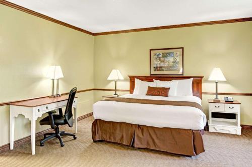 a hotel room with a bed and a desk at Provo River Inn in Provo