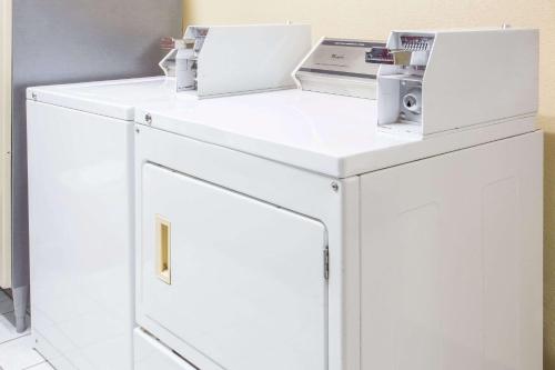 a white cabinet with two laptops on top of it at Baymont by Wyndham Muskegon in Muskegon