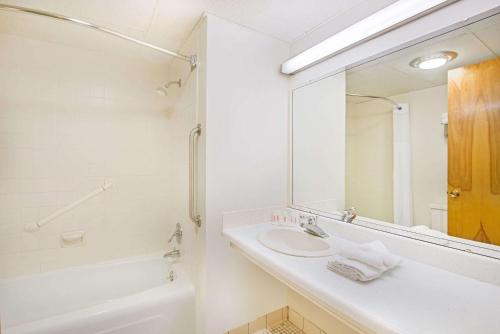 a white bathroom with a sink and a mirror at Baymont by Wyndham Sandusky in Sandusky