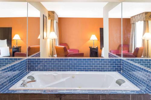 a large bath tub in a hotel room at Baymont by Wyndham Muskegon in Muskegon