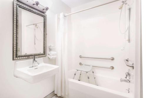 ein weißes Badezimmer mit einem Waschbecken und einem Spiegel in der Unterkunft Baymont by Wyndham LaGrange in LaGrange