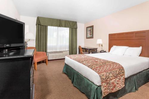a hotel room with two beds and a television at Baymont by Wyndham Yreka in Yreka