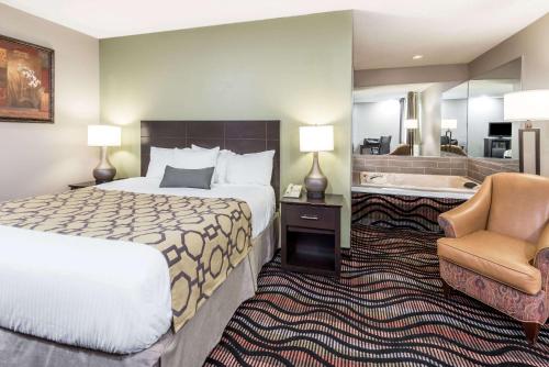 a hotel room with a bed and a bathroom at Baymont by Wyndham Cambridge in Cambridge