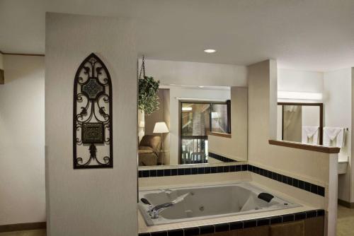 La grande salle de bains est pourvue d'une baignoire et d'un miroir. dans l'établissement Baymont by Wyndham Whitewater, à Whitewater