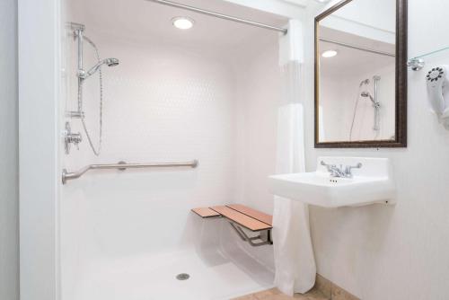 y baño blanco con lavabo y ducha. en Baymont by Wyndham Marshfield, en Marshfield