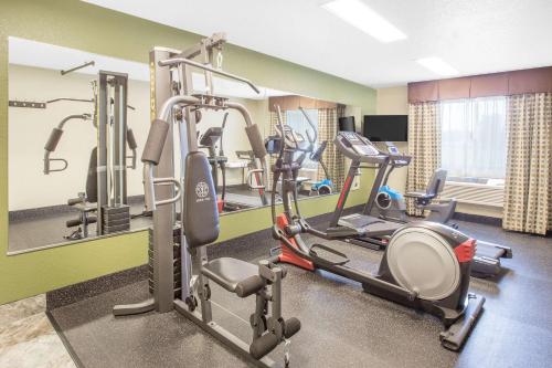 a gym with several tread machines in a room at Baymont by Wyndham Holland in Holland