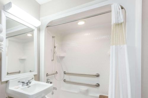 a white bathroom with a sink and a shower at Baymont by Wyndham Cambridge in Cambridge