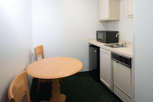 a small kitchen with a table and a microwave at Baymont by Wyndham Coeur D Alene in Coeur d'Alene