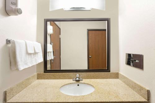 ein Badezimmer mit einem Waschbecken und einem großen Spiegel in der Unterkunft Baymont by Wyndham Beloit in Beloit