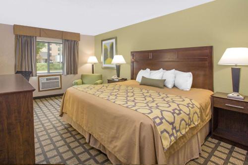 A bed or beds in a room at Baymont by Wyndham Ames