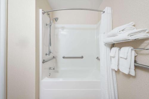 bagno con doccia e asciugamani bianchi di Baymont by Wyndham Fulton a Fulton