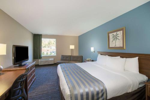 a hotel room with a large bed and a television at Baymont by Wyndham Bartonsville Poconos in Bartonsville