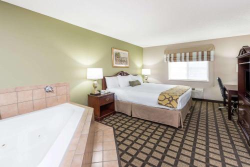 a hotel room with a bed and a desk at Baymont by Wyndham Fulton in Fulton