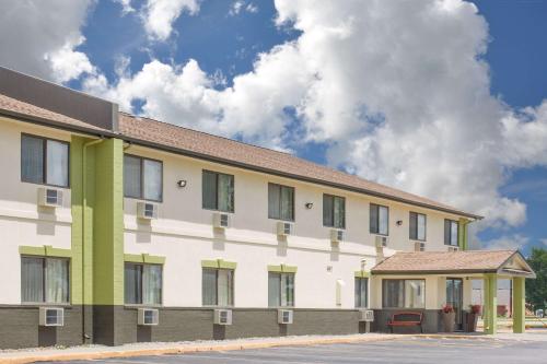 a white and green building with a sky in the background at Baymont by Wyndham Ames in Ames