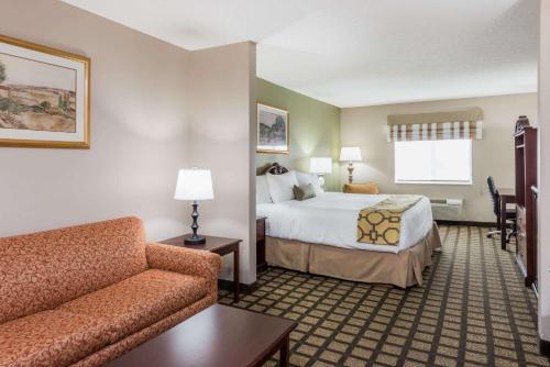 a hotel room with a bed and a couch at Baymont by Wyndham Fulton in Fulton