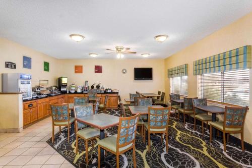 a restaurant with tables and chairs and a kitchen at Baymont by Wyndham Billings in Billings