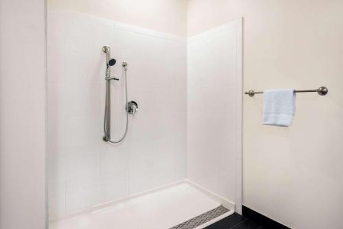 a white bathroom with a shower and a tub at Howard Johnson by Wyndham Quincy/ Boston in Quincy