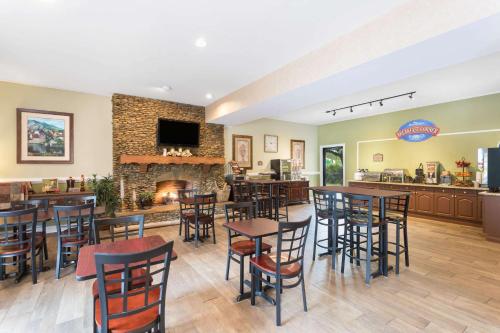 a restaurant with tables and chairs and a fireplace at Baymont by Wyndham Helen in Helen