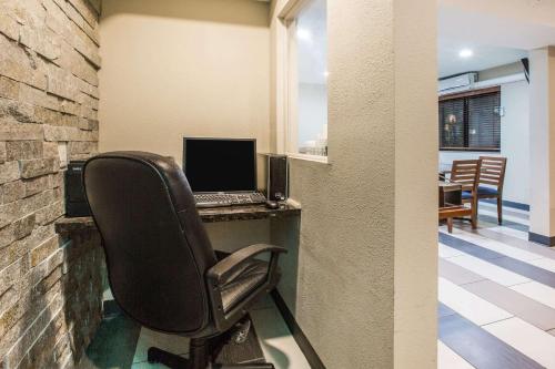 an office with a chair and a laptop on a desk at Baymont by Wyndham Cedar Rapids in Cedar Rapids