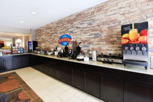 een bar in een restaurant met een bakstenen muur bij Baymont by Wyndham Auburn in Auburn