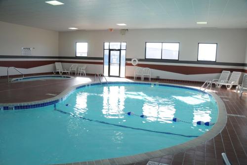 a large swimming pool in a room with chairs at Baymont by Wyndham West Plains in West Plains