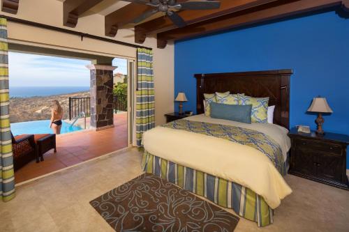 ein Schlafzimmer mit einem großen Bett und einem Balkon in der Unterkunft Montecristo Villas at Quivira Los Cabos -Vacation Rentals in Cabo San Lucas