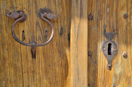 an old door with a handle on a wooden door at S'Ommu Ezza in Narbolia