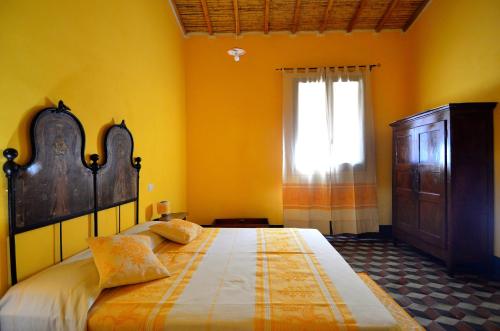 a bedroom with a large bed and a window at S'Ommu Ezza in Narbolia