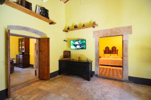 a room with a bedroom with a bed and a mirror at S'Ommu Ezza in Narbolia