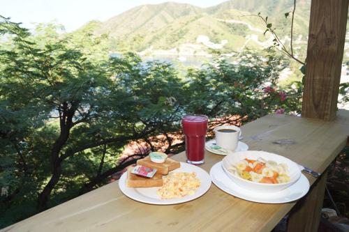 a table topped with plates of food and drinks at Hotel Cactus Taganga in Taganga