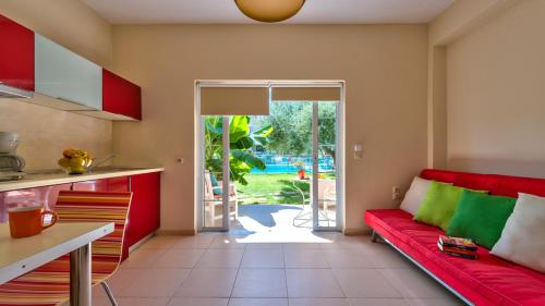 a living room with a red couch in a kitchen at Elea in Kato Daratso