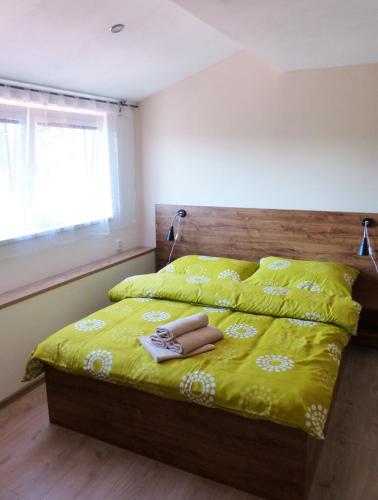 a bed with a yellow comforter and a pair of underwear on it at Penzion Amálka in Třeboň