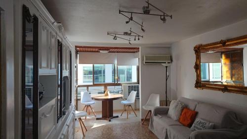 uma sala de estar com um sofá e uma mesa com cadeiras em La Explanada em Alicante