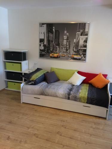 a bedroom with a bed with colorful pillows on it at Alte Schreinerei in Veringendorf