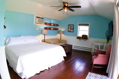 a bedroom with a white bed and a blue wall at The Ledges Resort & Marina in Alexandria Bay
