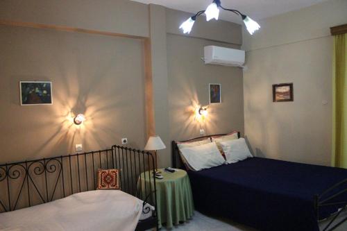 アギオス・ゲオルギオスにあるVilla Nefeliのベッドルーム1室(ベッド2台、テーブル、照明付)