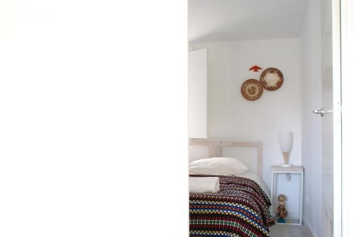 コインブラにあるCasa de Cimaのベッドルーム1室(ベッド1台、壁掛け時計付)