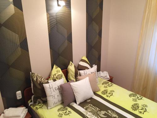 a bedroom with a bed with pillows on it at Príma Vendégház in Tiszakécske