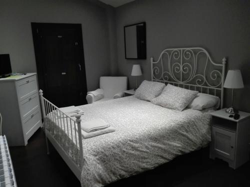 a bedroom with a white bed and a black dresser at Casa Rural Kutxatxuri in Aracaldo