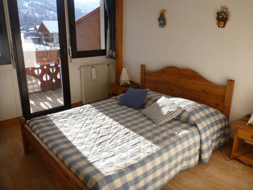 a bedroom with a bed with a blue pillow on it at Résidence Flor'alp in Samoëns