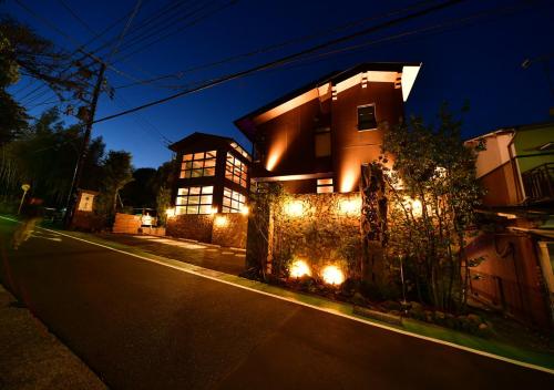 uma casa com luzes ao lado de uma rua em Balinese onsen ryokan Hakone Airu em Hakone