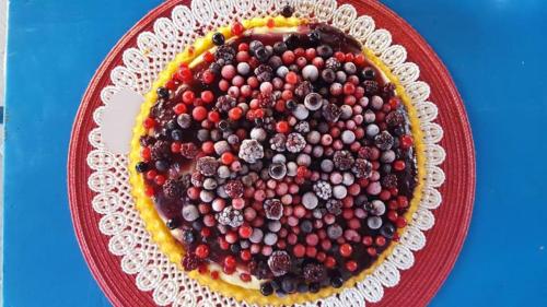 a red plate with a cake with berries on it at L'Oasi Villaggio Albergo in Favignana
